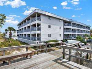 an apartment building with a wooden boardwalk in front of it at Oceanview Bliss in Tybee Island