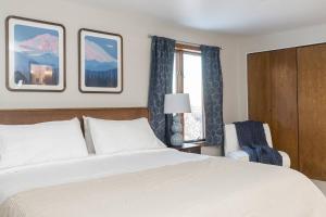 a bedroom with a bed and a chair and a window at Group Escape: 6BR Hot Tub, Sauna, Game Rm & Garage in Lemeta