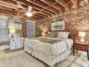 a brick walled bedroom with a bed and a ceiling fan at Riverview Terrace in Savannah
