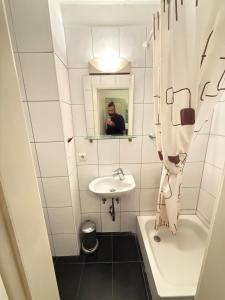 Kölner Hotel في كولونيا: رجل يصور حمام مع مغسلة +32 صورة