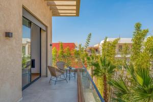 a patio with a table and chairs on a balcony at Villa LUMA - Akenza Residence in El Rhechat