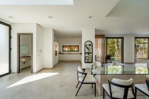 a living room with a glass table and chairs at Villa LUMA - Akenza Residence in El Rhechat