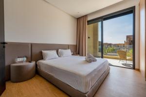 a bedroom with a large bed and a large window at Villa LUMA - Akenza Residence in El Rhechat +85 photos