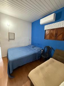 Habitación azul con cama y silla en Encanto potiguar sol e mar, en Natal