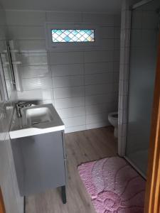 a bathroom with a sink and a toilet and a window at Maison de Lily in Cier-de-Luchon