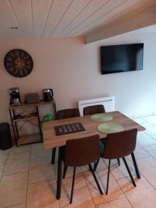 a dining room with a table and chairs and a clock at Maison de Lily in Cier-de-Luchon
