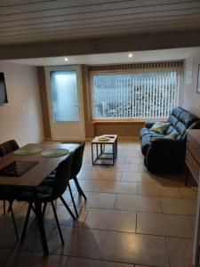 a living room with a couch and a table at Maison de Lily in Cier-de-Luchon +2 photos