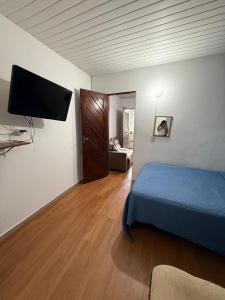 Un dormitorio con una cama y un televisor de pantalla plana. en Encanto potiguar sol e mar, en Natal