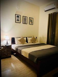 TirupporūrにあるGatorgetaway innのベッドとランプ付きのテーブルがある寝室