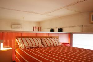 パドヴァにあるLoft Padovaのベッドルーム1室(オレンジと白のストライプのベッド1台付)