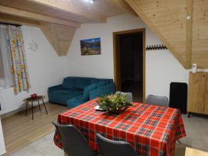 a living room with a table and a blue couch at Apartamenty Tatrzańska Dolina in Kościelisko