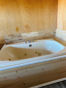 een bad in een kamer met een houten muur bij Country Inn - Licking in Licking