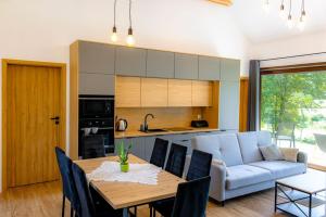 Domki nad potokiem في Lipnica Murowana: مطبخ وغرفة معيشة مع طاولة وأريكة