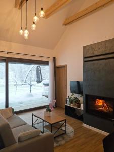 Domki nad potokiem في Lipnica Murowana: غرفة معيشة مع أريكة ومدفأة