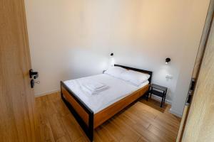 Domki nad potokiem في Lipnica Murowana: غرفة نوم صغيرة مع سرير مع ملاءات بيضاء