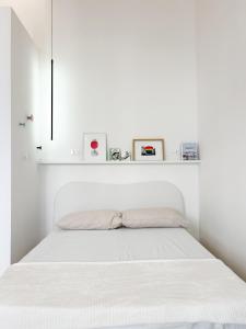 富切基奥Civico 21 living Tuscan loft的白色卧室,配有一张带白色床头板的床