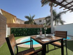 a table and chairs in a backyard with a pool at Palmview Private Pool in Arguineguín