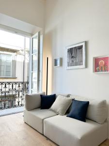 富切基奥Civico 21 living Tuscan loft的客厅配有带蓝色枕头的白色沙发