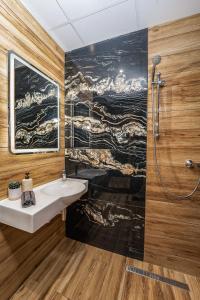 a bathroom with a sink and a painting on the wall at Best Central Lux Studio in Bansko