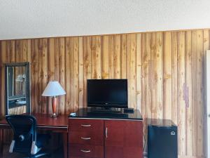 een kamer met een bureau, een televisie en een stoel bij Country Inn - Licking in Licking