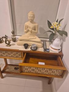 una statua di Buddha seduta su un tavolo di Casa del Mare a Wattala