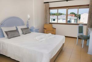 a bedroom with a large white bed and a window at Residencial San Fernando in Ponte da Barca +12 photos