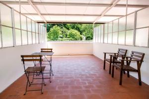 an empty room with chairs and tables and windows at Residencial San Fernando in Ponte da Barca