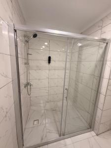 een douche met een glazen deur in een badkamer bij Mütena konaklama in Mudanya