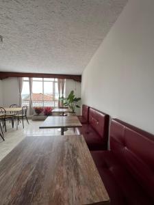 a dining room with tables and red leather booths at Casa Epifania Miraflores hostel in Cali