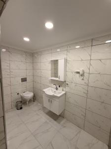 een witte badkamer met een wastafel en een toilet bij Mütena konaklama in Mudanya +4 foto's