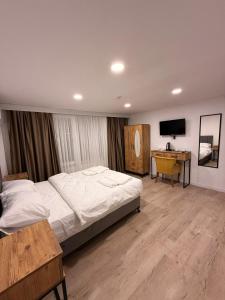een slaapkamer met een bed, een bureau en een televisie bij Mütena konaklama in Mudanya