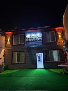een gebouw met een bord aan de zijkant 's nachts bij Mütena konaklama in Mudanya