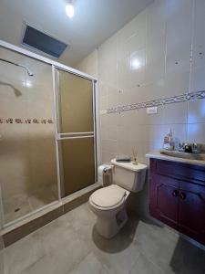 a bathroom with a shower and a toilet and a sink at Casa Epifania Miraflores hostel in Cali +29 photos
