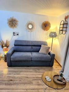 ein Wohnzimmer mit einem blauen Sofa und einem Tisch in der Unterkunft Maison de ville Chaleureuse au cœur de Chartres Netflix, garage vélos in Chartres