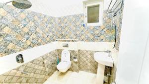 un baño con inodoro y lavabo en Orchid Highland, en Dehradun 9 fotos más