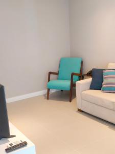 a living room with a couch and a chair at Unique Residence Lindo Apartamento Vista Mar e garagem in Santos +2 photos