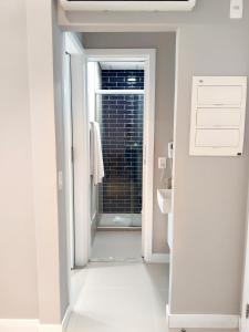 a bathroom with a door leading into a bathroom with a window at Unique Residence Lindo Apartamento Vista Mar e garagem in Santos