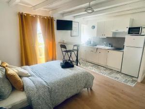 a bedroom with a bed and a small kitchen at L'Escapade Charentaise Central et calme in La Rochefoucauld