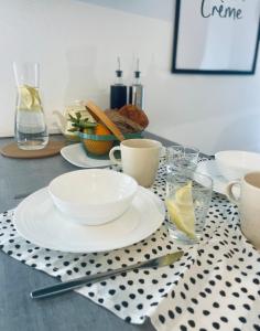 a table with plates and cups on a polka dot table cloth at Studio spacieux et calme - Parking facile in La Rochefoucauld