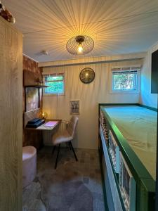 Habitación con cama y escritorio. en Cozy escape near Den Bosch - 4 PS chalet met veel privacy en rust!, en Lith