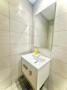 a bathroom with a white sink and a mirror at Majestic Residence KLCC By Homestay in Kuala Lumpur