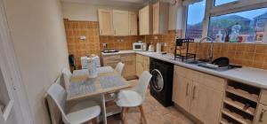 une cuisine avec une table, des chaises et un évier dans l'établissement Cavan Havan, à Broadstone