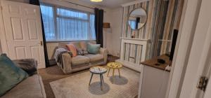 - un salon avec un canapé, une chaise et un miroir dans l'établissement Cavan Havan, à Broadstone