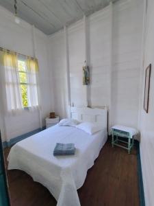 una camera bianca con un grande letto bianco e due finestre di Hospedagem Maranata a Santo André Altre 9 foto