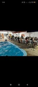 a large swimming pool with people sitting in chairs next to it at Área de Itans in Caicó