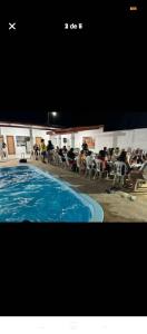 a picture of a swimming pool with people sitting in chairs at Área de Itans in Caicó