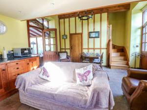 a bedroom with a bed and a kitchen and a staircase at Maggie's Barn in Talgarth