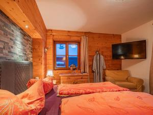 a bedroom with two beds and a television in a room at Haus David in Kirchberg in Tirol