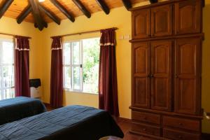 1 Schlafzimmer mit 2 Betten und einem großen Holzschrank in der Unterkunft Ñanderoga Bungalows in Colón