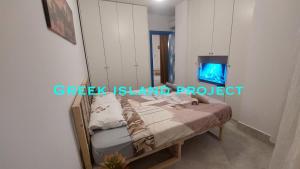 sypialnia z łóżkiem i telewizorem na ścianie w obiekcie Greek island Project w Tiranie